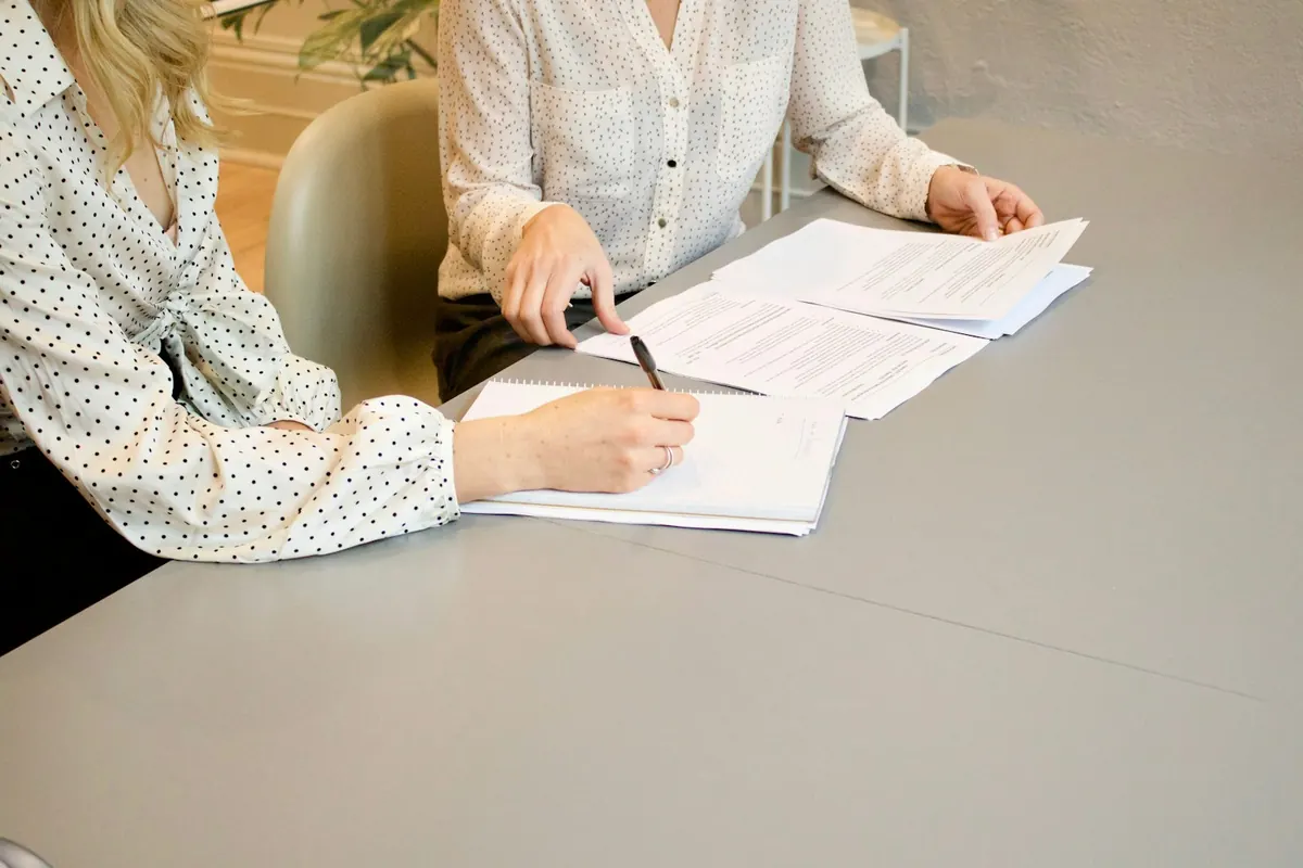 An attorney guiding a client through documents at signing