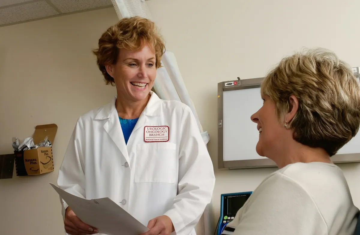 A doctor in a white coat talking with a patient in a clinic